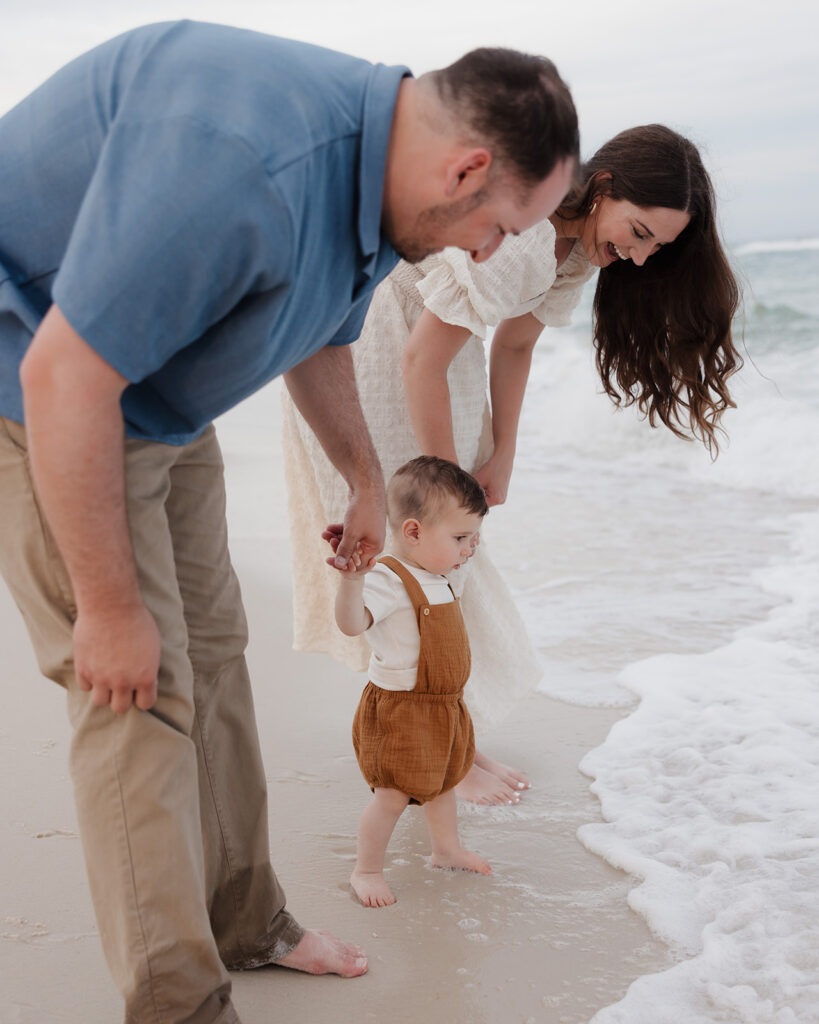 a young family splashes in the waves on Pensacola Beach