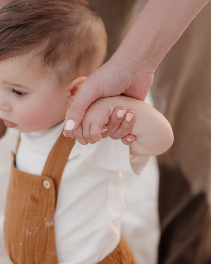 mom holds baby's hand