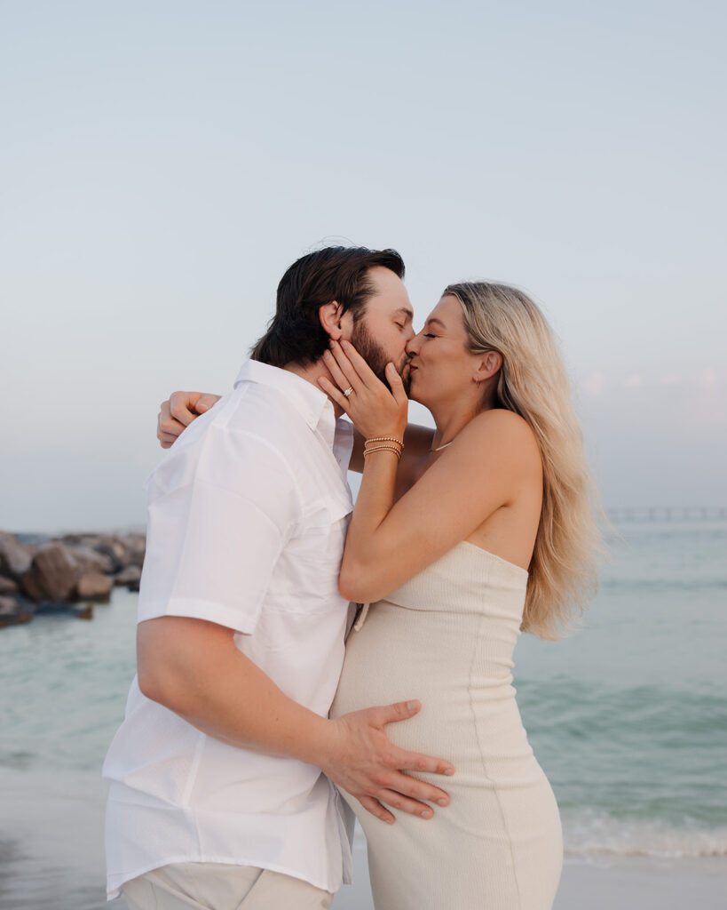 woman and man kiss on Destin, Florida beach