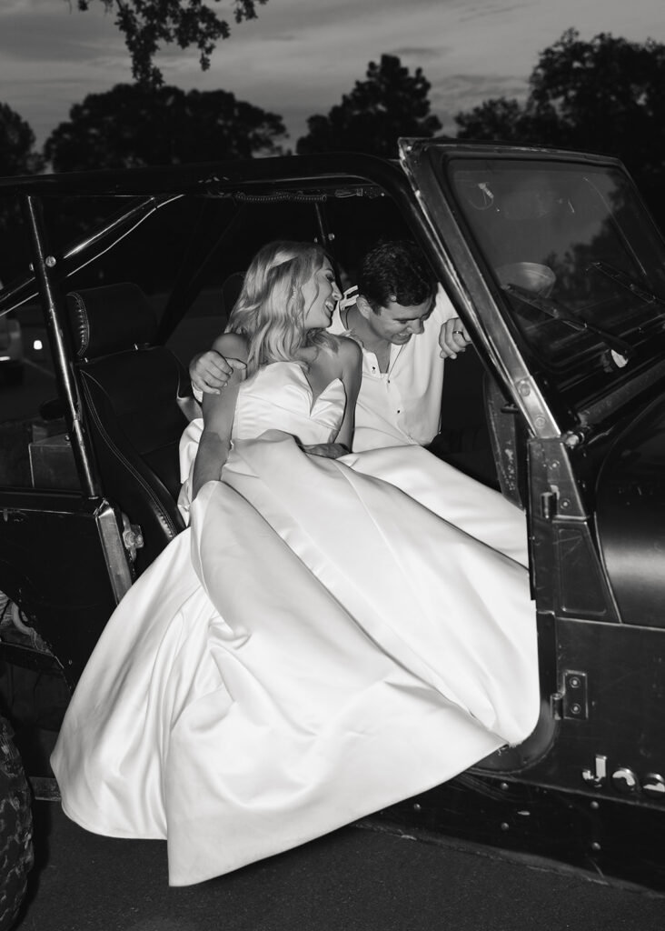 bride and groom leave their wedding in a jeep