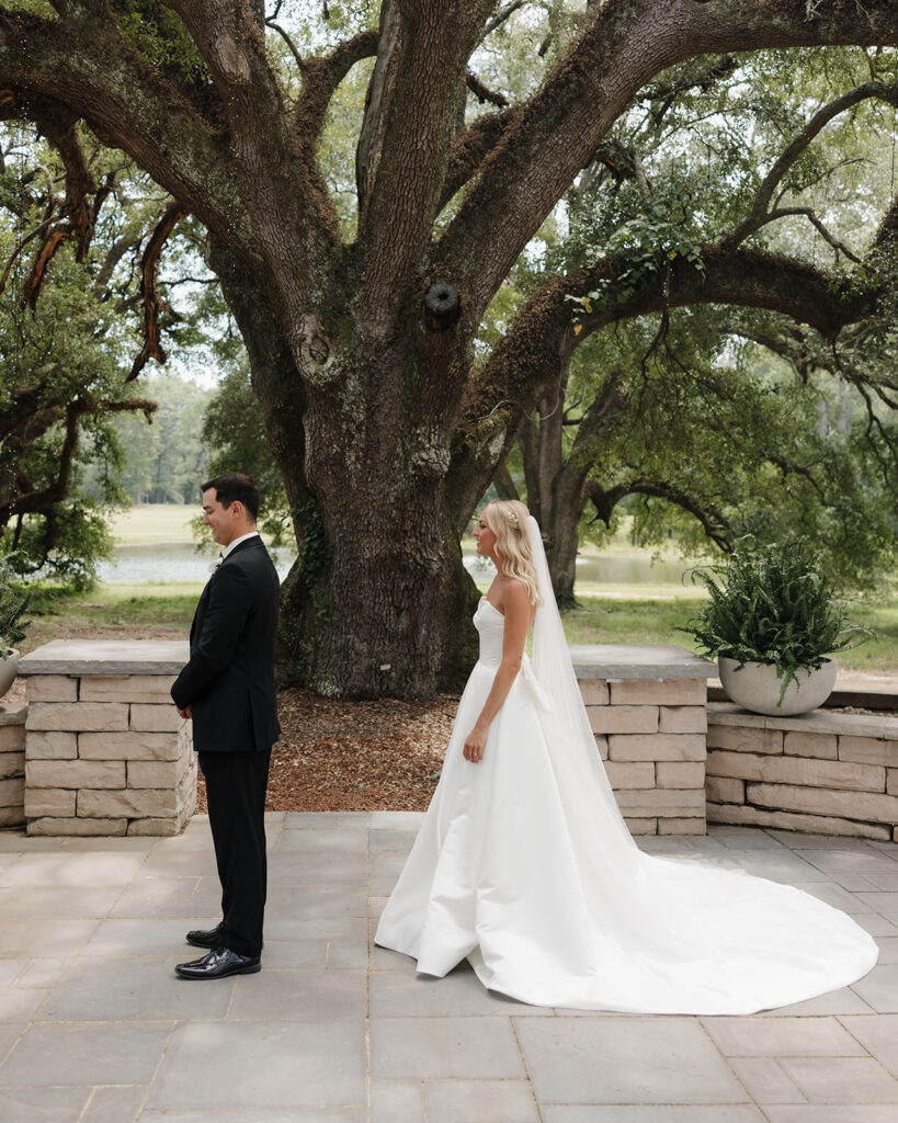 bride and groom stand by the tree at the Reed House in Jackson, MS