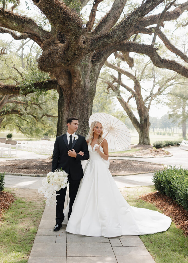 bride and groom stand by an oak tree at the Reed House in Jackson, MS