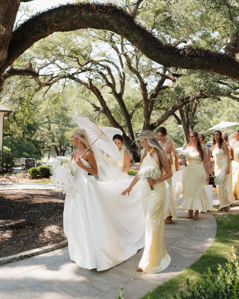 bride and bridesmaids walk along a pathway