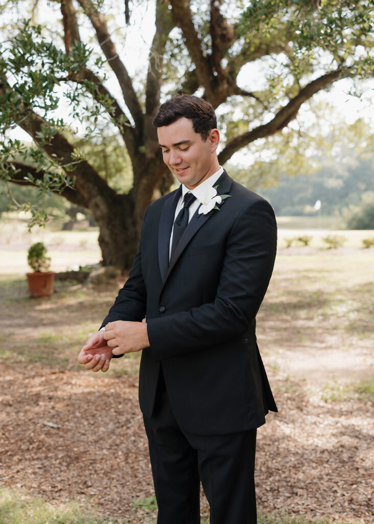 groom adjusts his sleeves