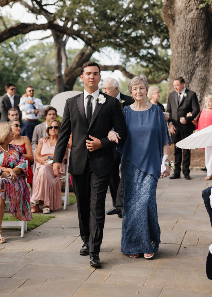 groom and grandmother walk down the aisle