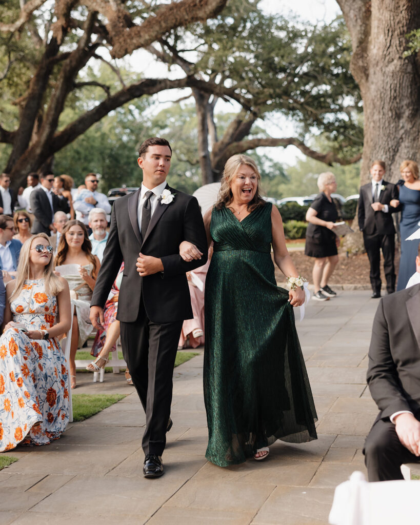 groom and mother walk down the aisle