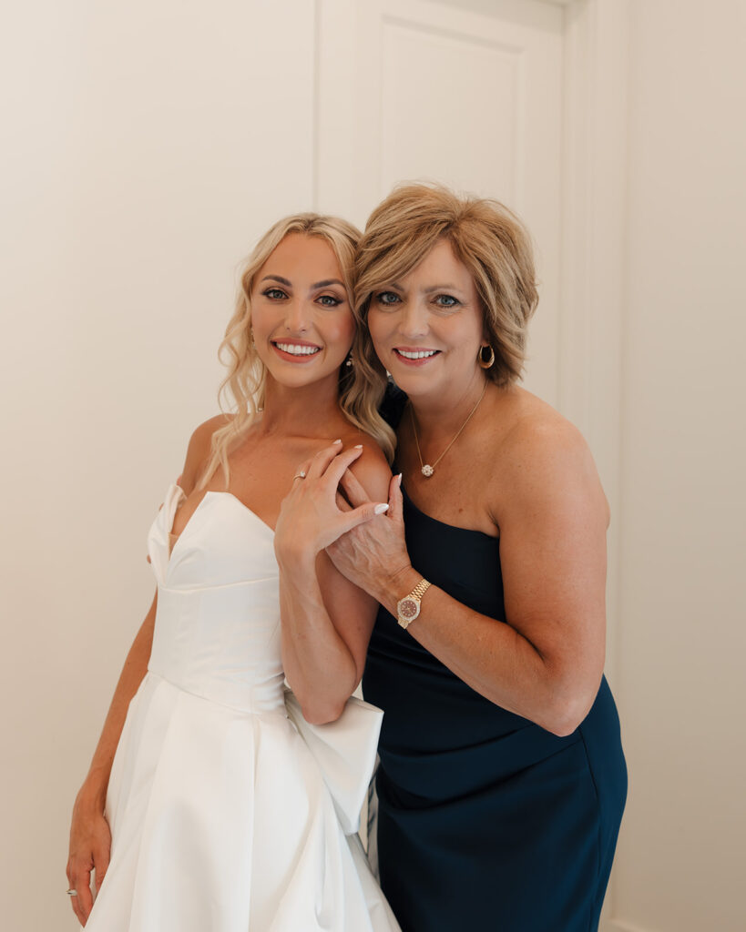 bride and mom smile for a photo