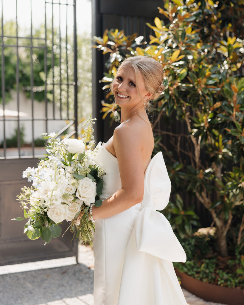 bride smiles in front of Supposey Warehouse and Gardens