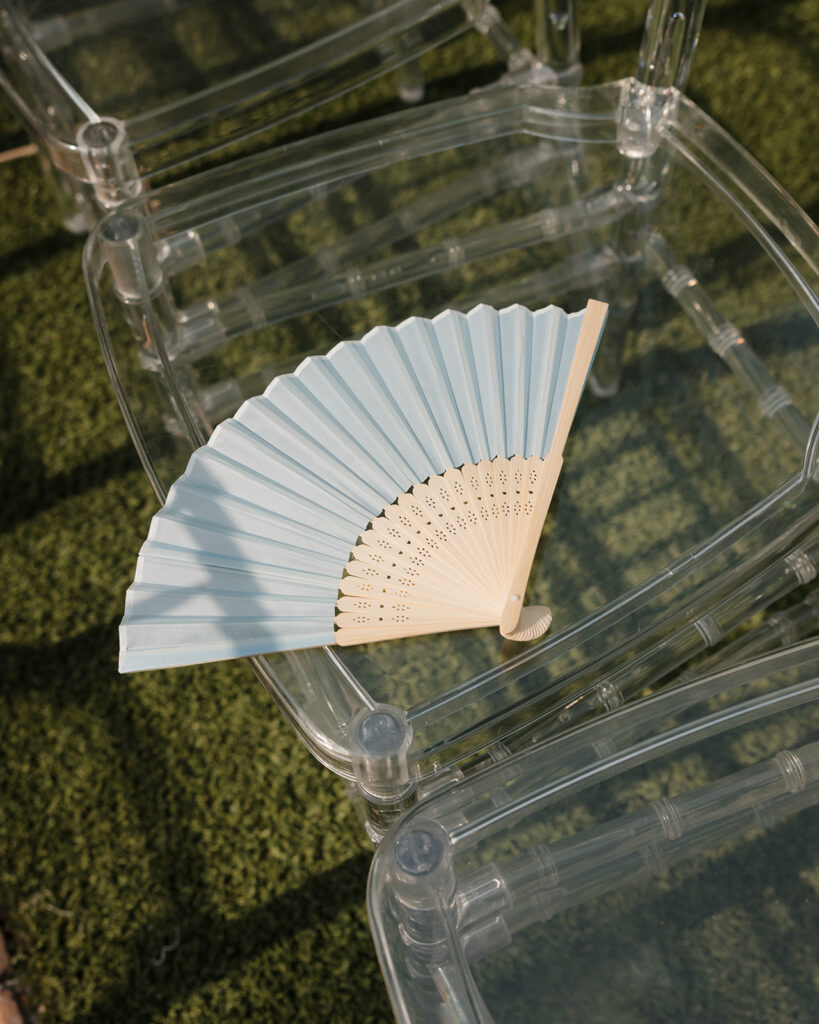 a paper fan rests on a ceremony chair