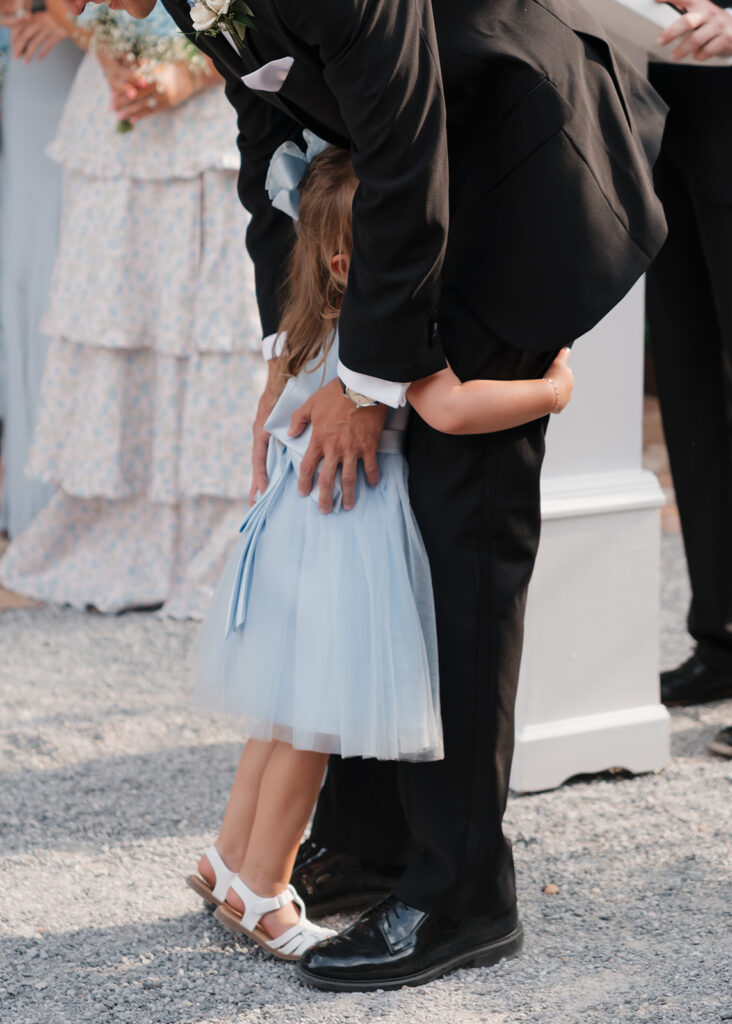 flower girl hugs the groom