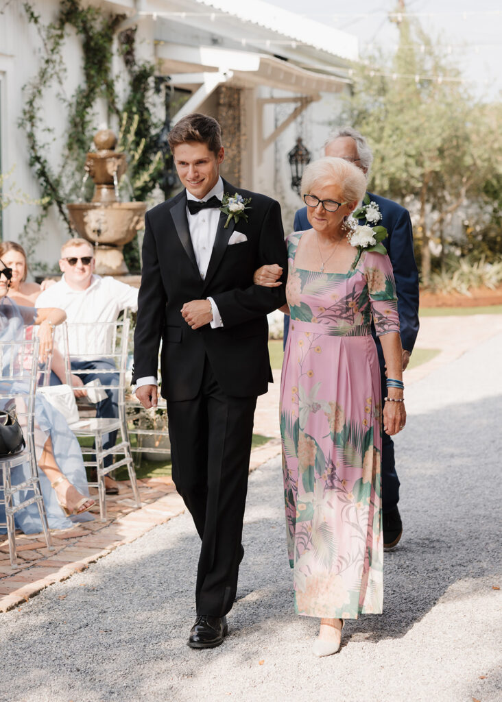 groom and parents walk down the aisle