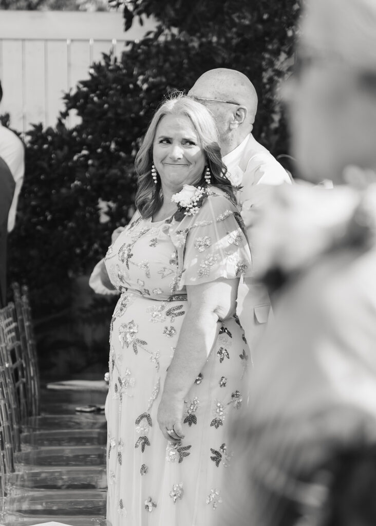 mother of the bride reacts to bride walking down the aisle