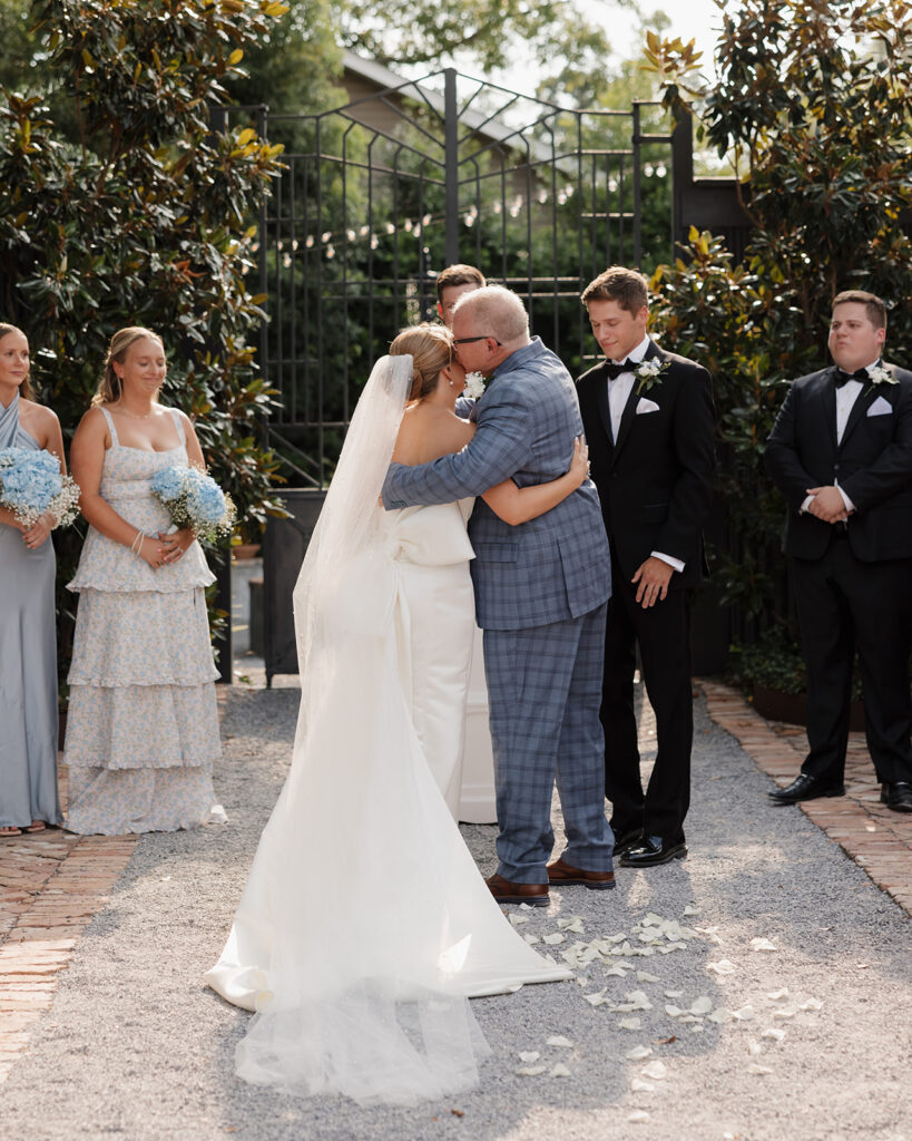 father kisses bride's cheek