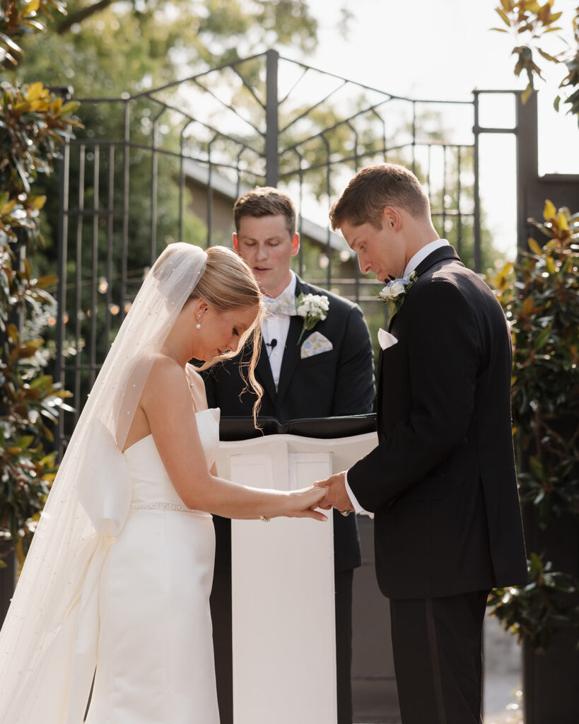 bride and groom hold hands during their wedding ceremony