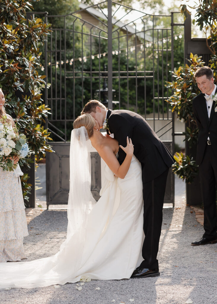 bride and groom share their first kiss