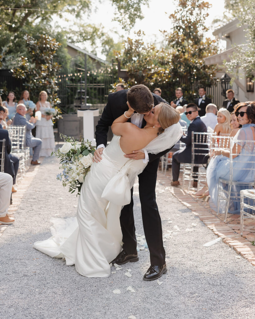 bride and groom dip kiss down the aisle