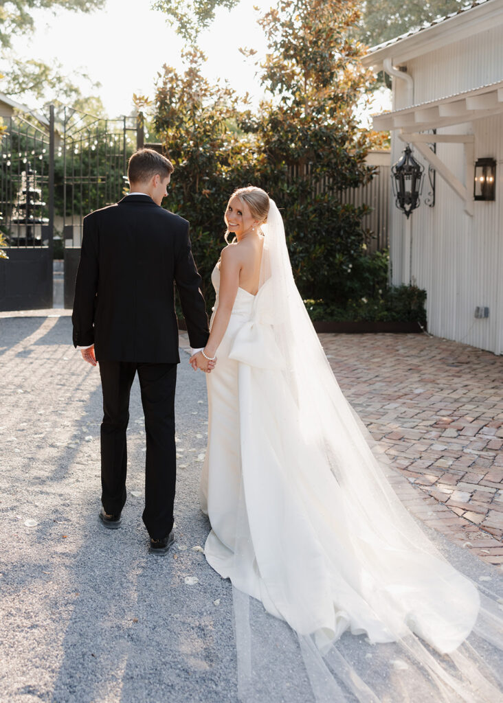 bride smiles as she and her groom walk away