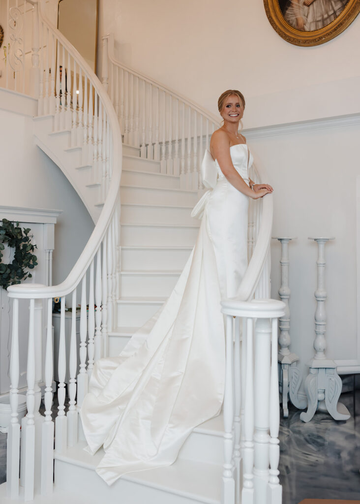 bride stands on a beautiful white staircase