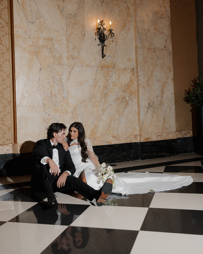 bride and groom sit in a room full of black and white checkered floor