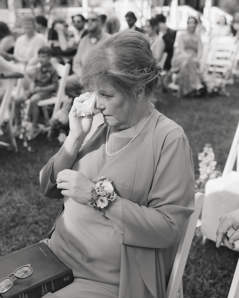 mother of the groom wipes away her tears