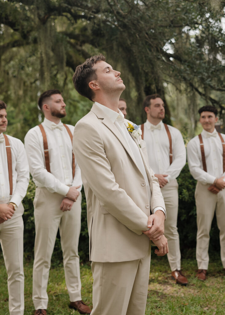 groom watches his bride walk down the aisle