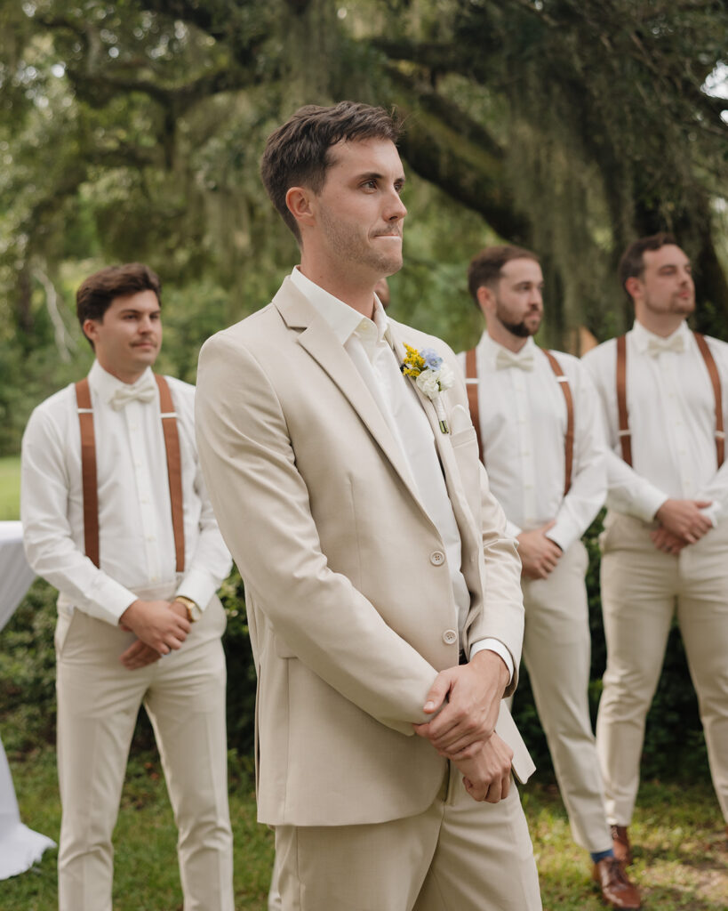 groom watches his bride walk down the aisle