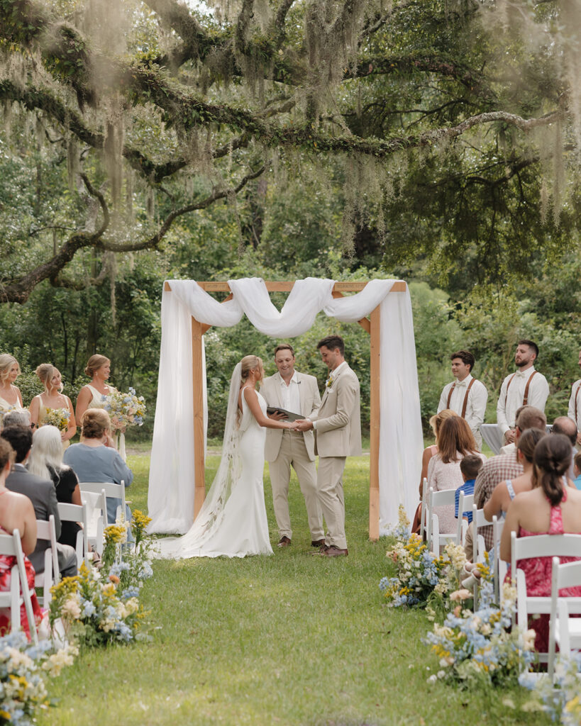 bride and groom hold hands during their wedding ceremony