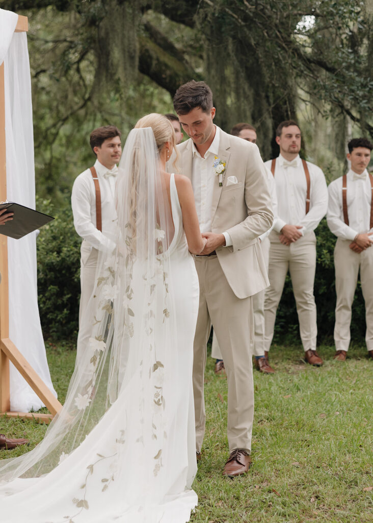 bride and groom hold hands during their wedding ceremony