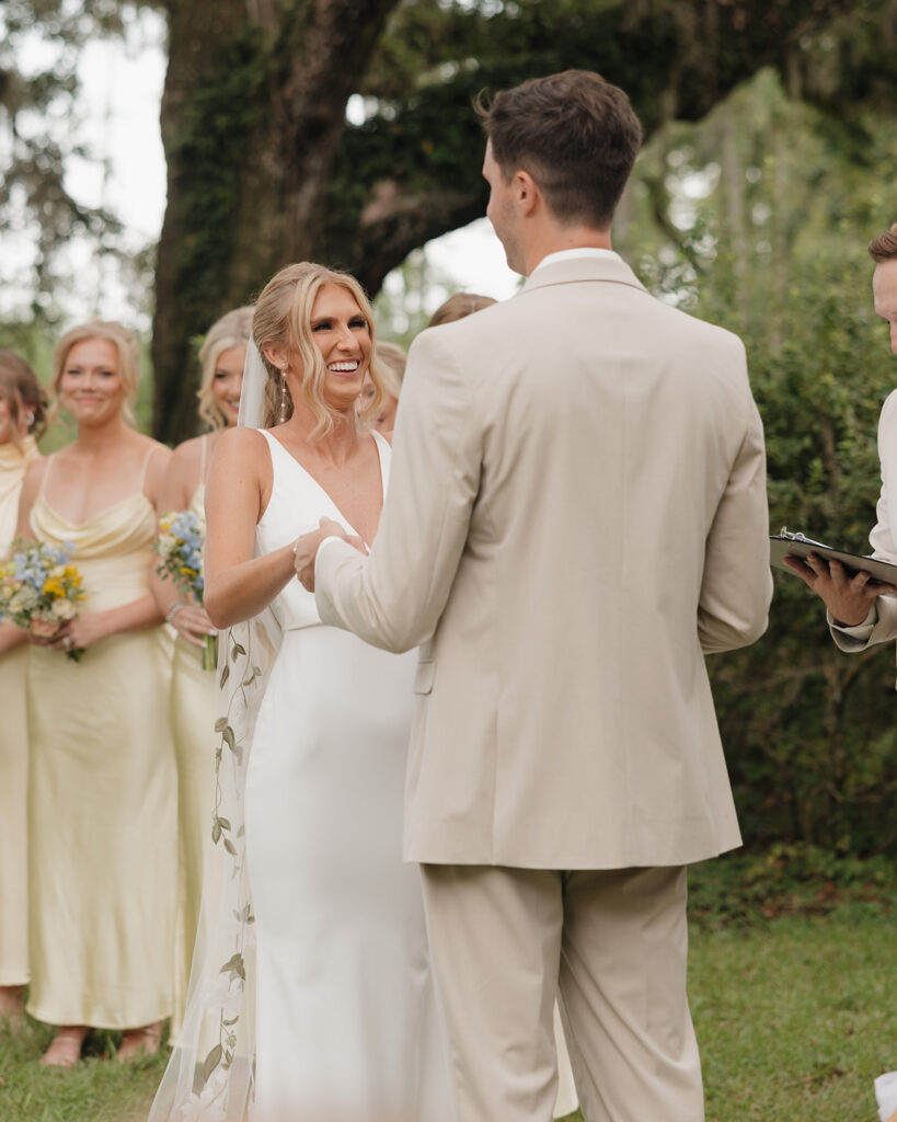 bride and groom hold hands during their wedding ceremony