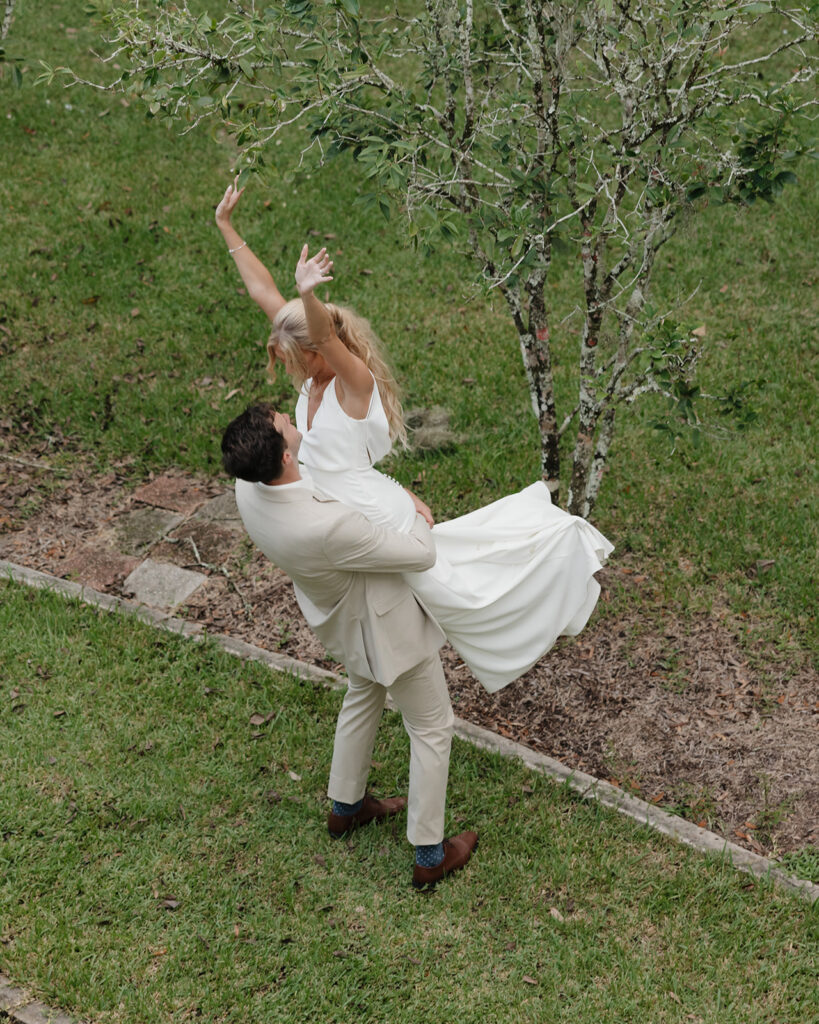 groom lifts bride in the air