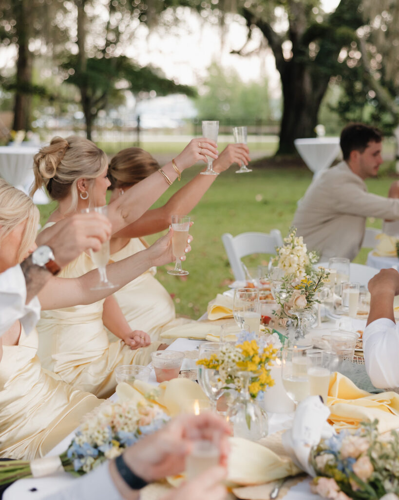 bridesmaids hold up champagne glasses