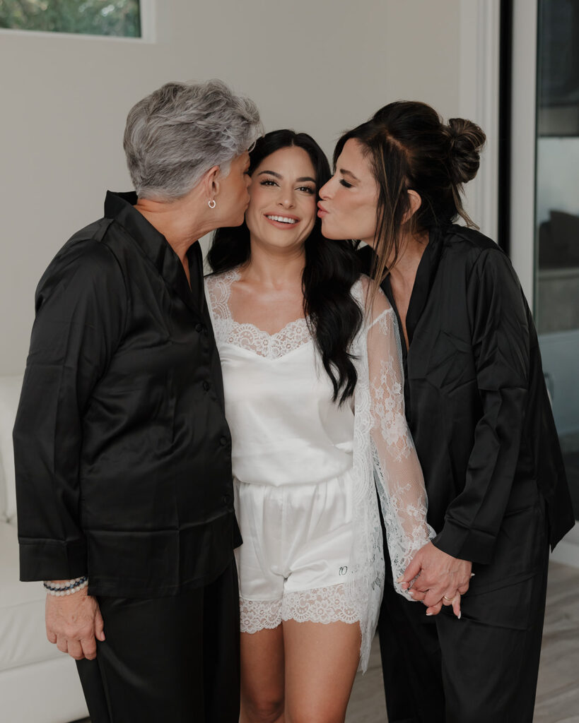 the bride's mother kisses her on the cheek