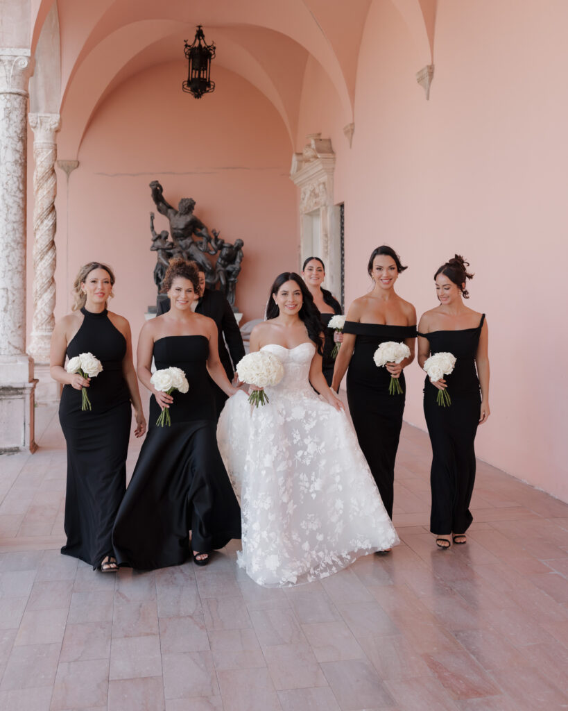 bride and bridesmaids walk through the Ringling courtyard