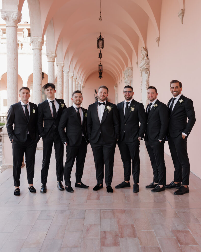 groom and groomsmen stand in the Ringling courtyard