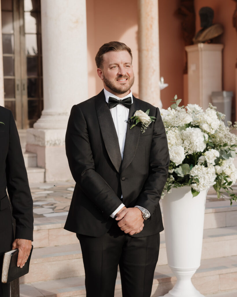 groom smiles as he sees his bride