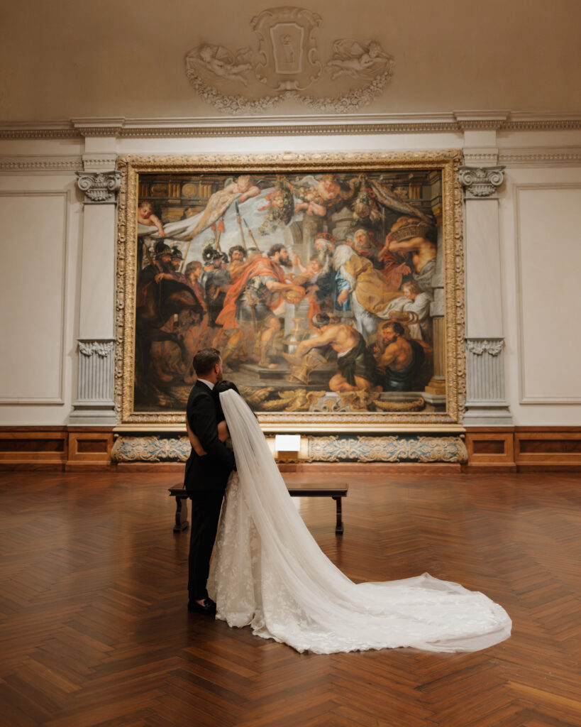 bride and groom look at the paintings inside of the Ringling museum