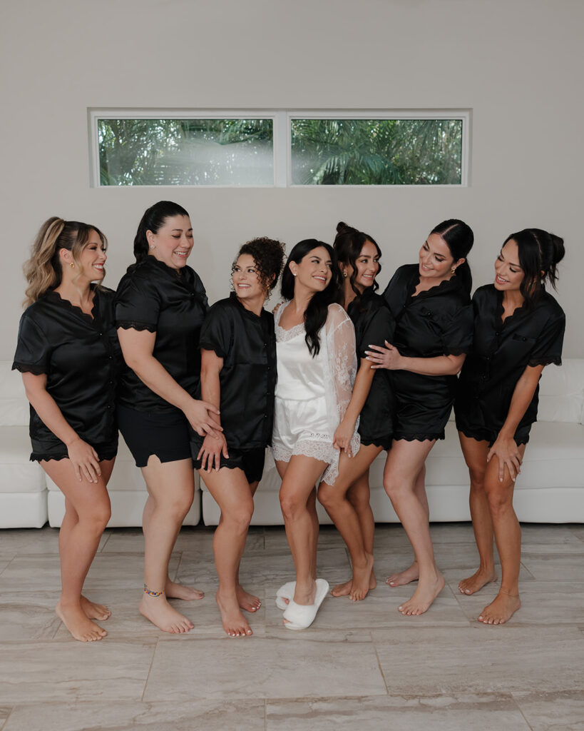 bride and bridesmaids laugh in their matching pajamas