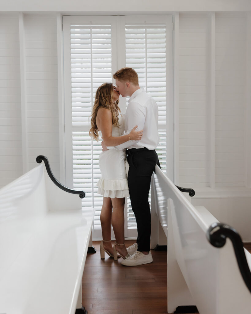 bride and groom kiss in the pews at the Seaside chapel