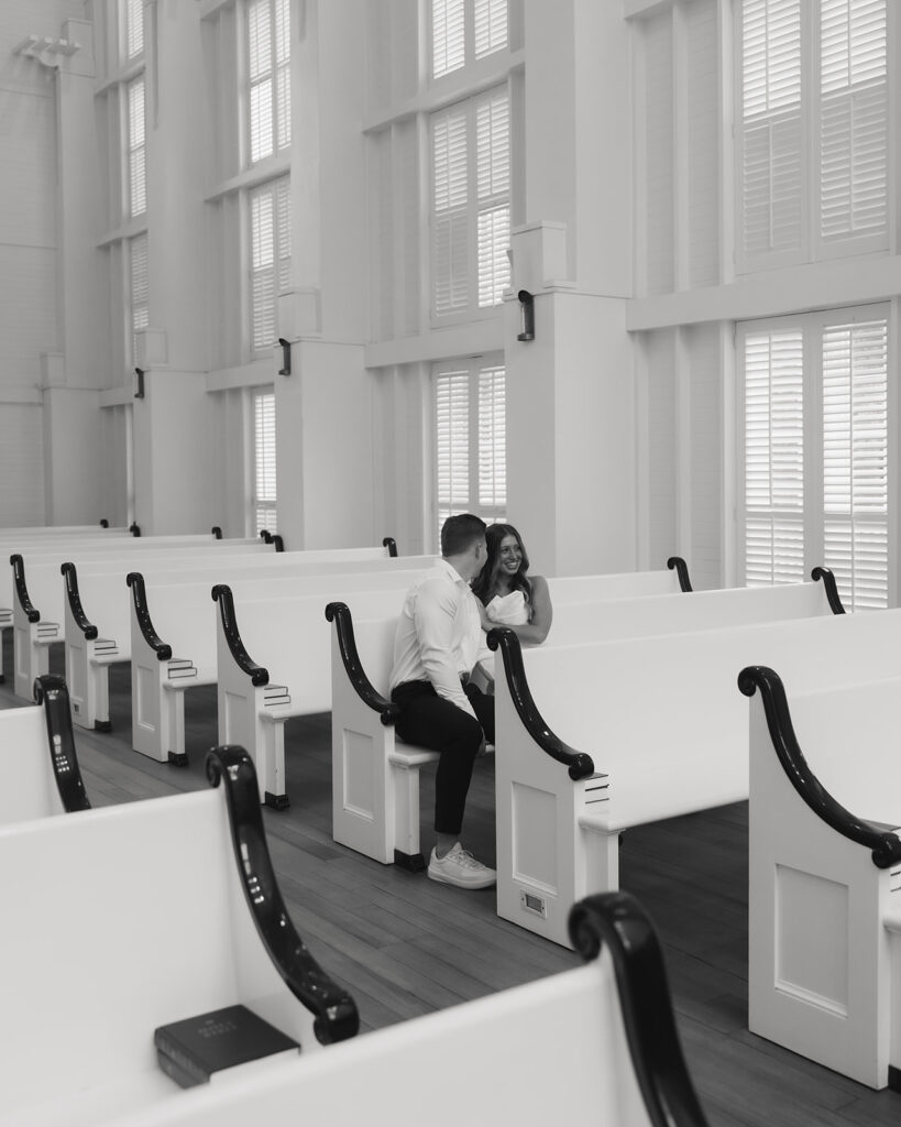 man and woman sit in the chapel pews