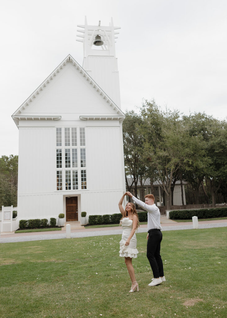 woman twirls in front of the Seaside Chapel