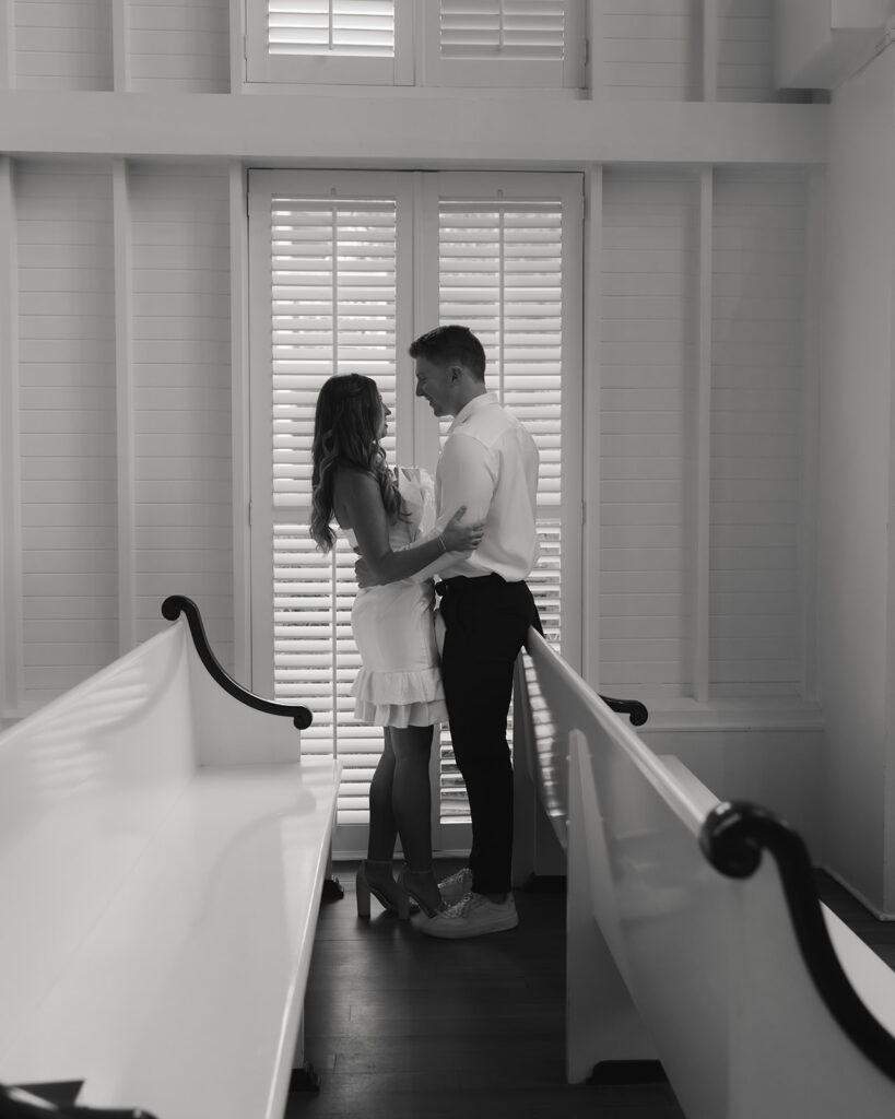 bride and groom hug in the pews of the chapel