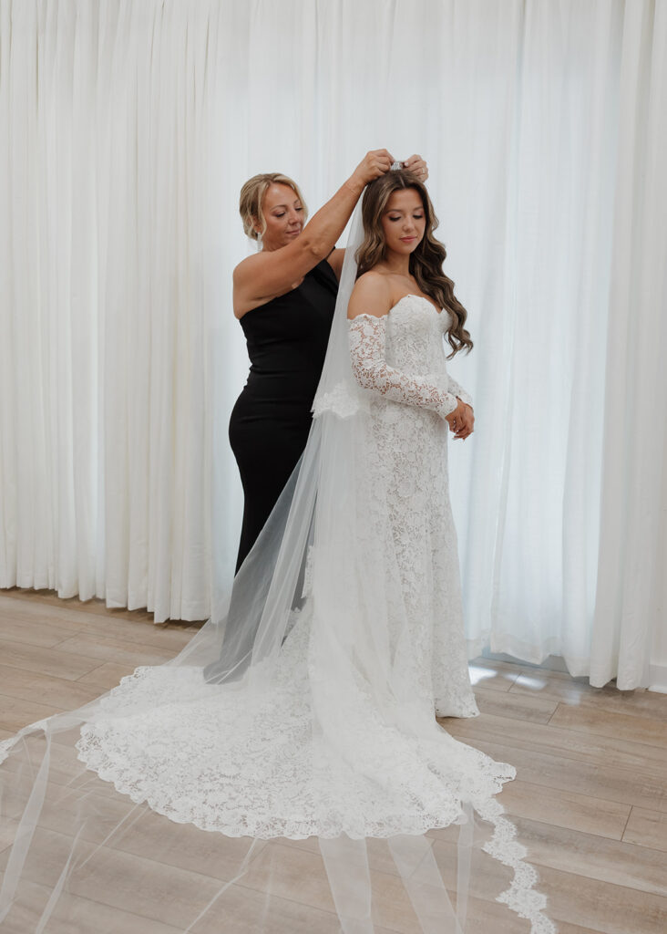 bride has her veil placed in her hair