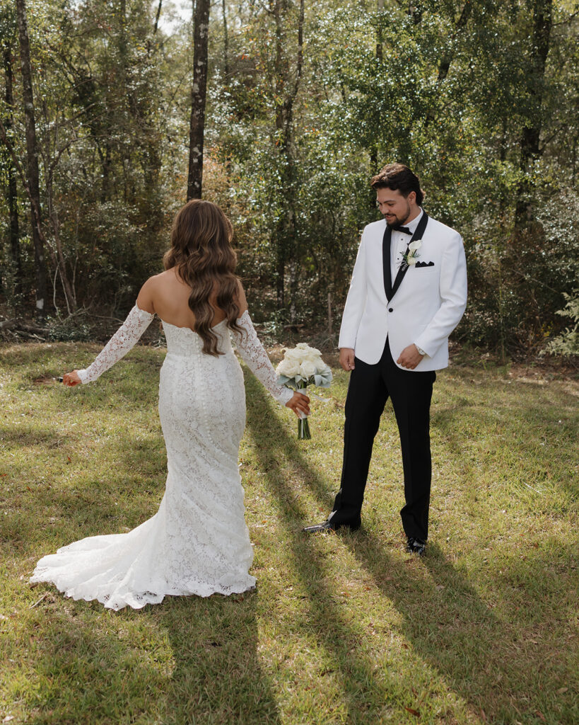 groom admires bride's wedding gown