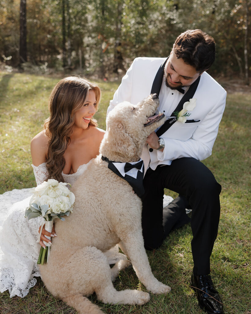 bride and groom pet their dog