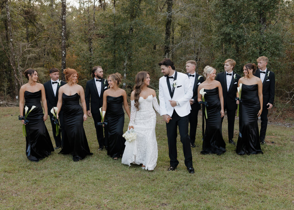 bride and groom walk with their wedding party