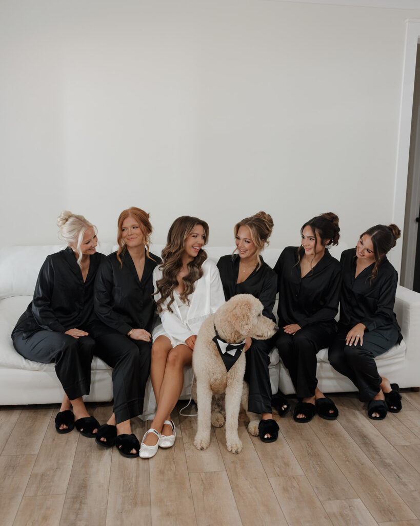 bride and bridesmaids sit on a couch