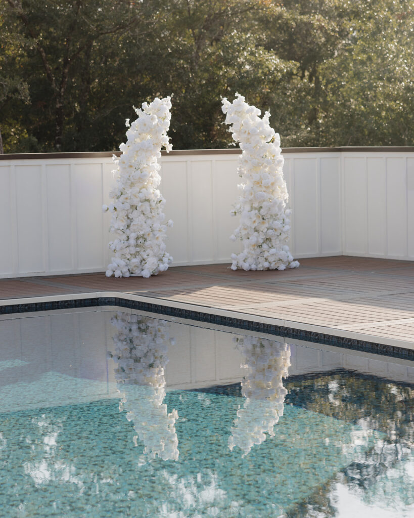 white flower arch by the pool