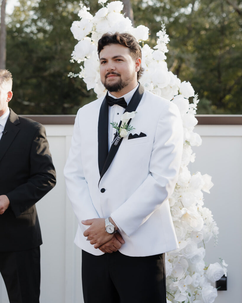 groom watches the bride walk down the aisle