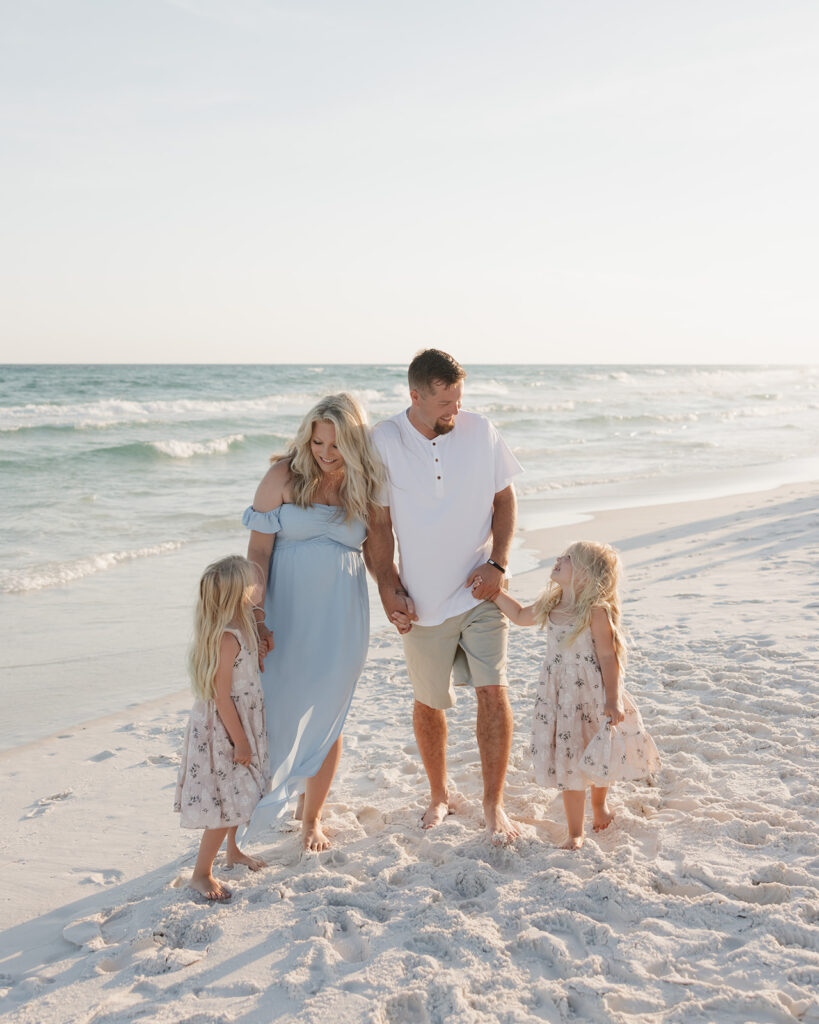 family of four walks on the beach near Seaside FL