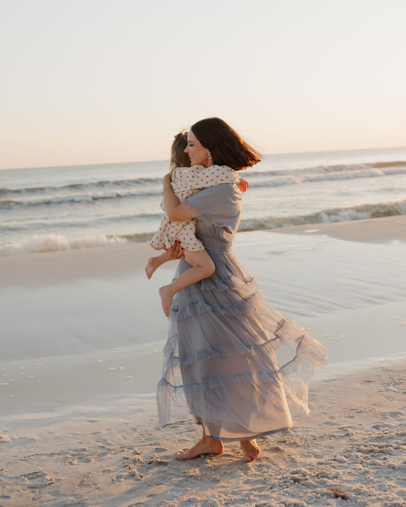 mother and daughter dance on the beach